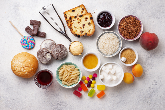 Zuckerhaltige Lebensmittel auf einem Tisch, Lolly, Eiscreme, Kuchen, Süßigkeiten, Obst, Kekse, Zuckerwürfel