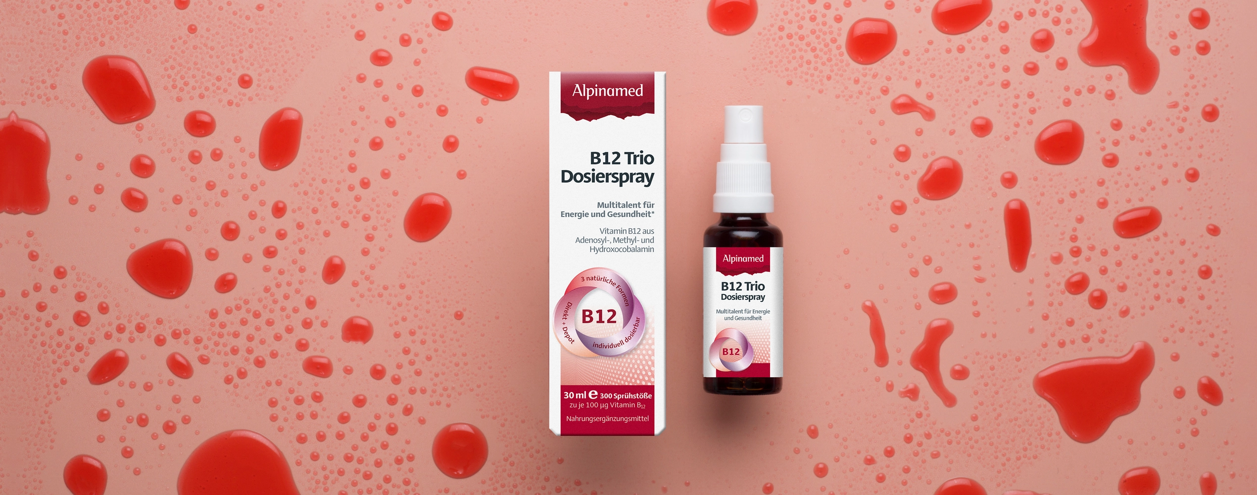 Vitamin B12 Spray Packung liegend mit Flüssigkeitsspritzern darum.